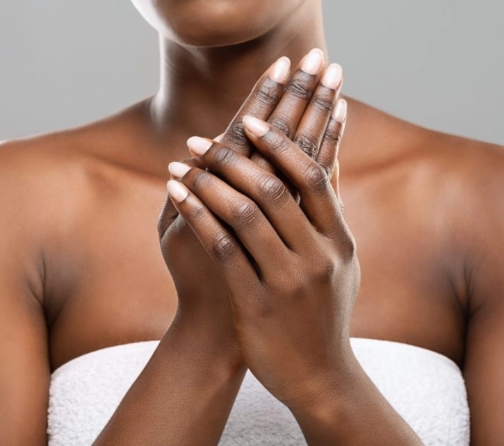 Avanor afro woman applying moisturizer